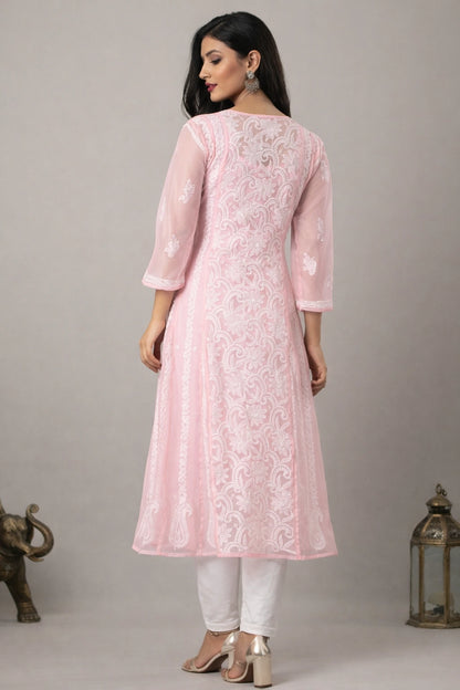 Woman wearing a pink embroidered kurta with white pants against a gray background