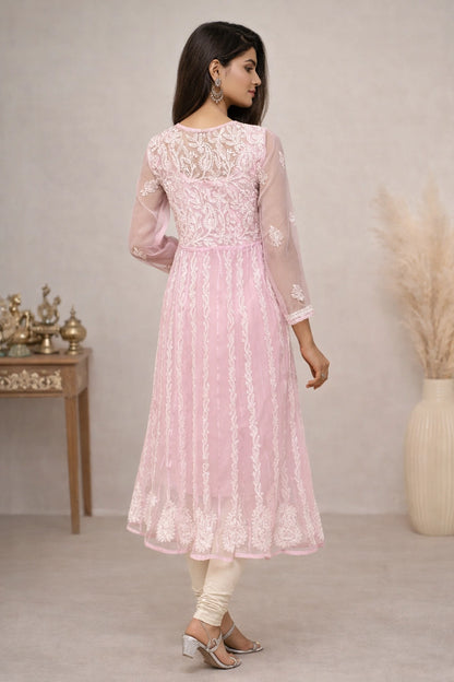 Woman wearing a pink embroidered dress in a minimalistic setting