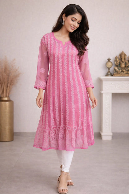 Woman wearing a pink kurta with white pants in an indoor setting.