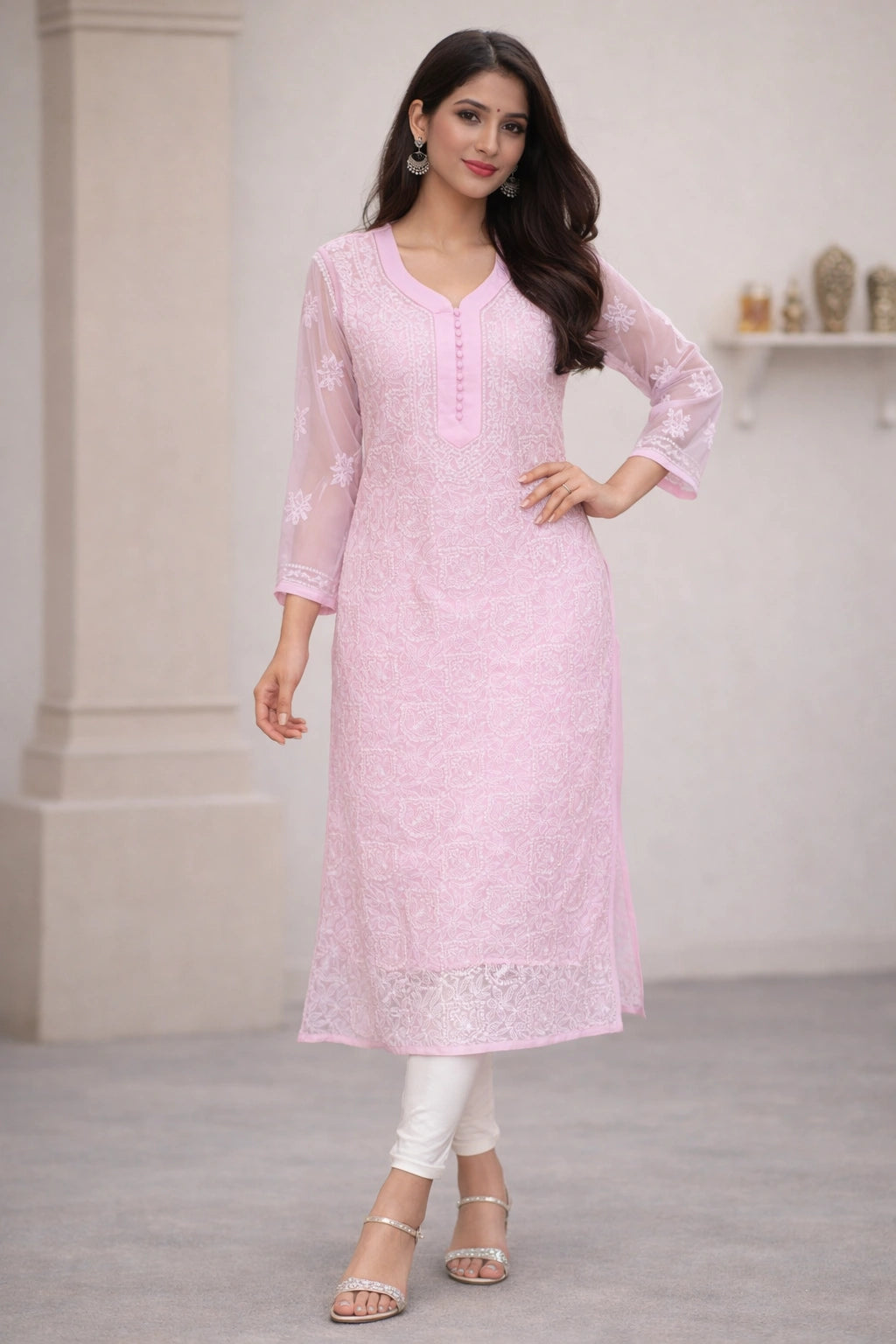 Woman wearing a lucknowi chikankari light pink kurta with white pants in an indoor setting