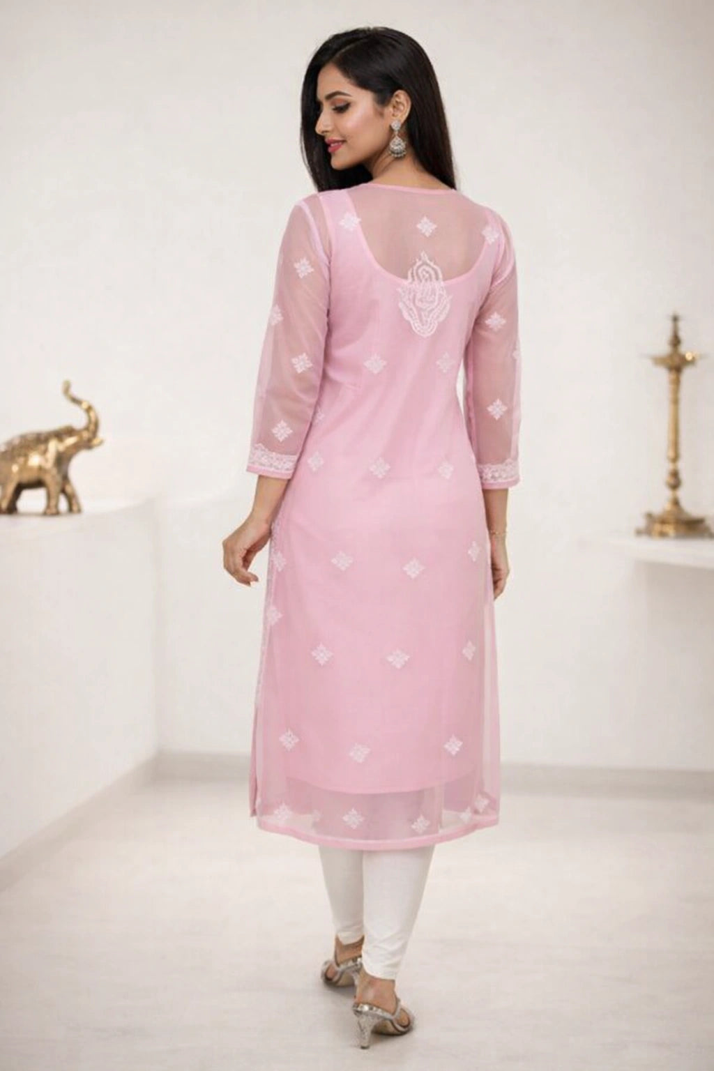 Woman wearing a lucknowi chikan pink kurta with white patterns in a minimalistic setting