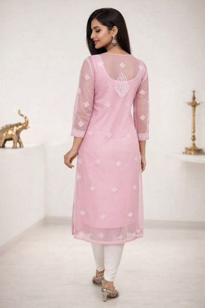Woman wearing a lucknowi chikan pink kurta with white patterns in a minimalistic setting