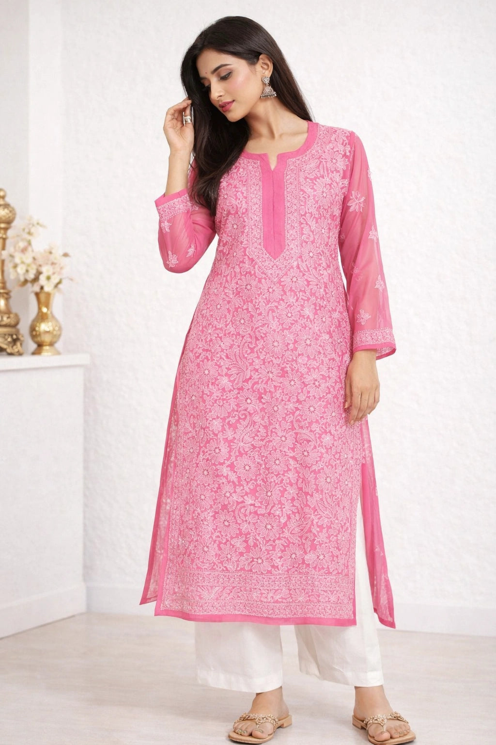 Woman wearing a lucknowi chikankari pink kurta with white pants in a minimalistic setting