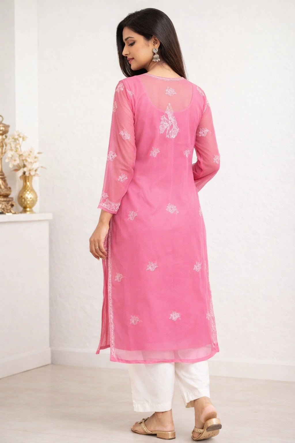 Woman wearing a lucknowi  pink kurta with white floral patterns on a white background