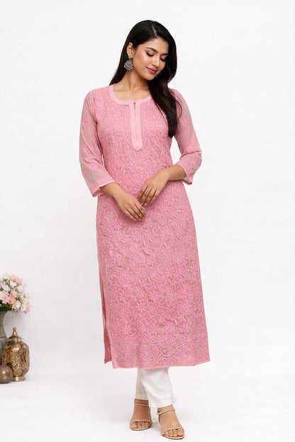 Woman wearing a lucknowi chikankari pink kurta with white pants on a white background