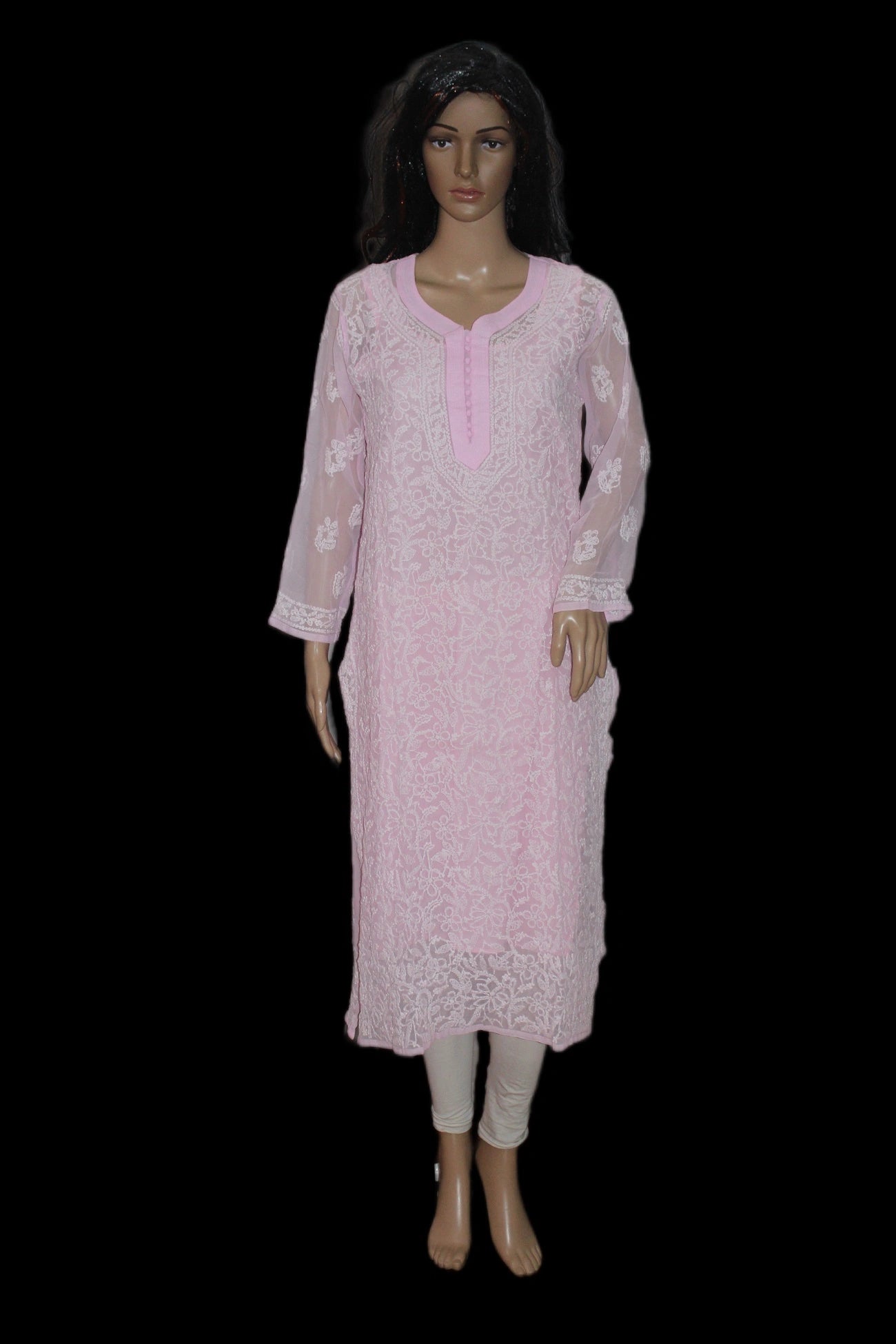 Mannequin wearing a light pink traditional outfit with white embroidery on a black background