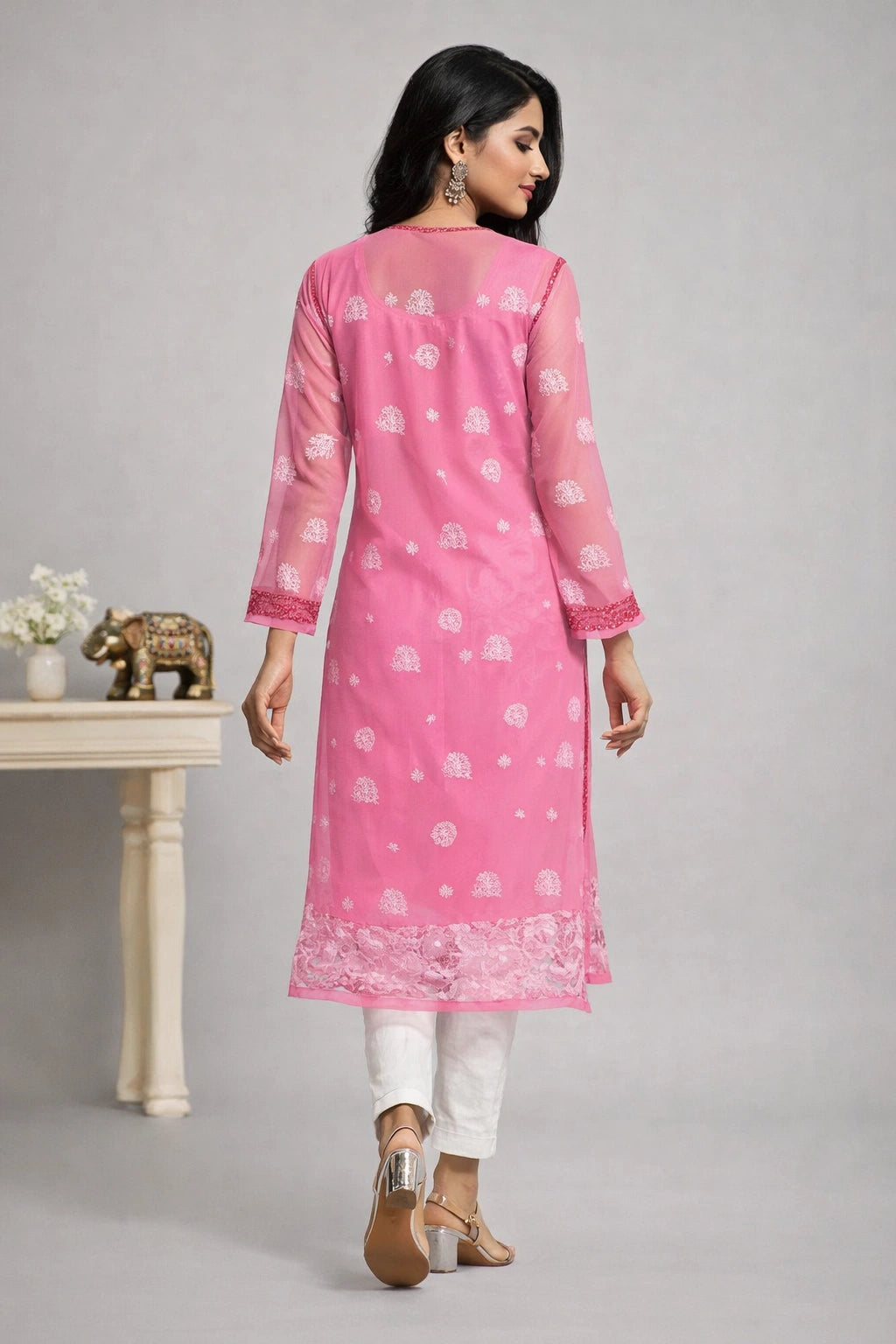 Woman wearing a chikan kadhai pink kurta with white patterns on a gray background