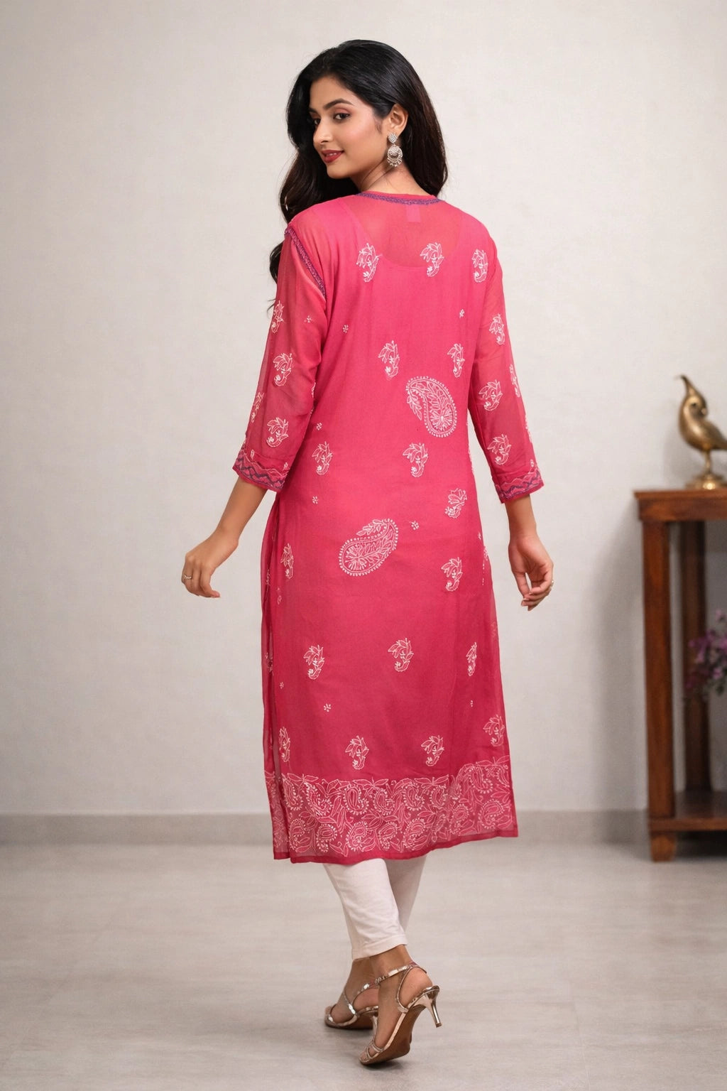 Woman wearing a lucknowi chikankari pink kurta with white patterns in a minimal indoor setting