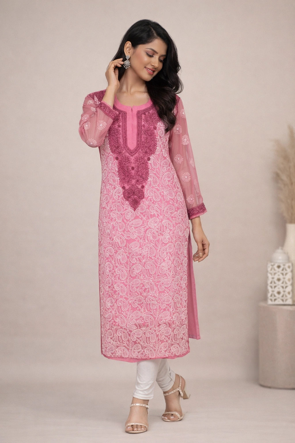 Woman wearing a pink embroidered kurta with white pants against a beige background