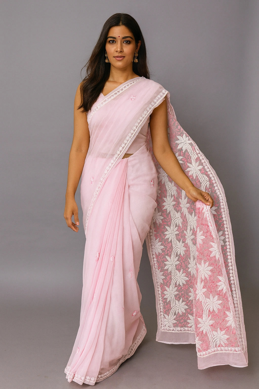 Woman wearing a lucknowi chikankari  light pink saree with white floral patterns on a gray background