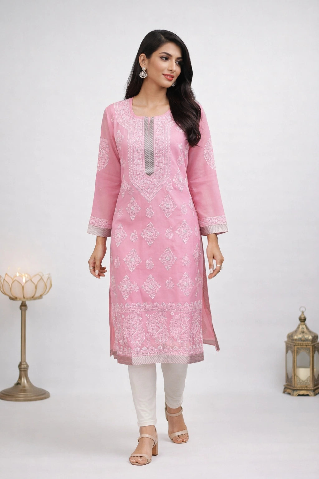 Woman wearing a pink kurta with white patterns of lucknowi embroidery on a white background