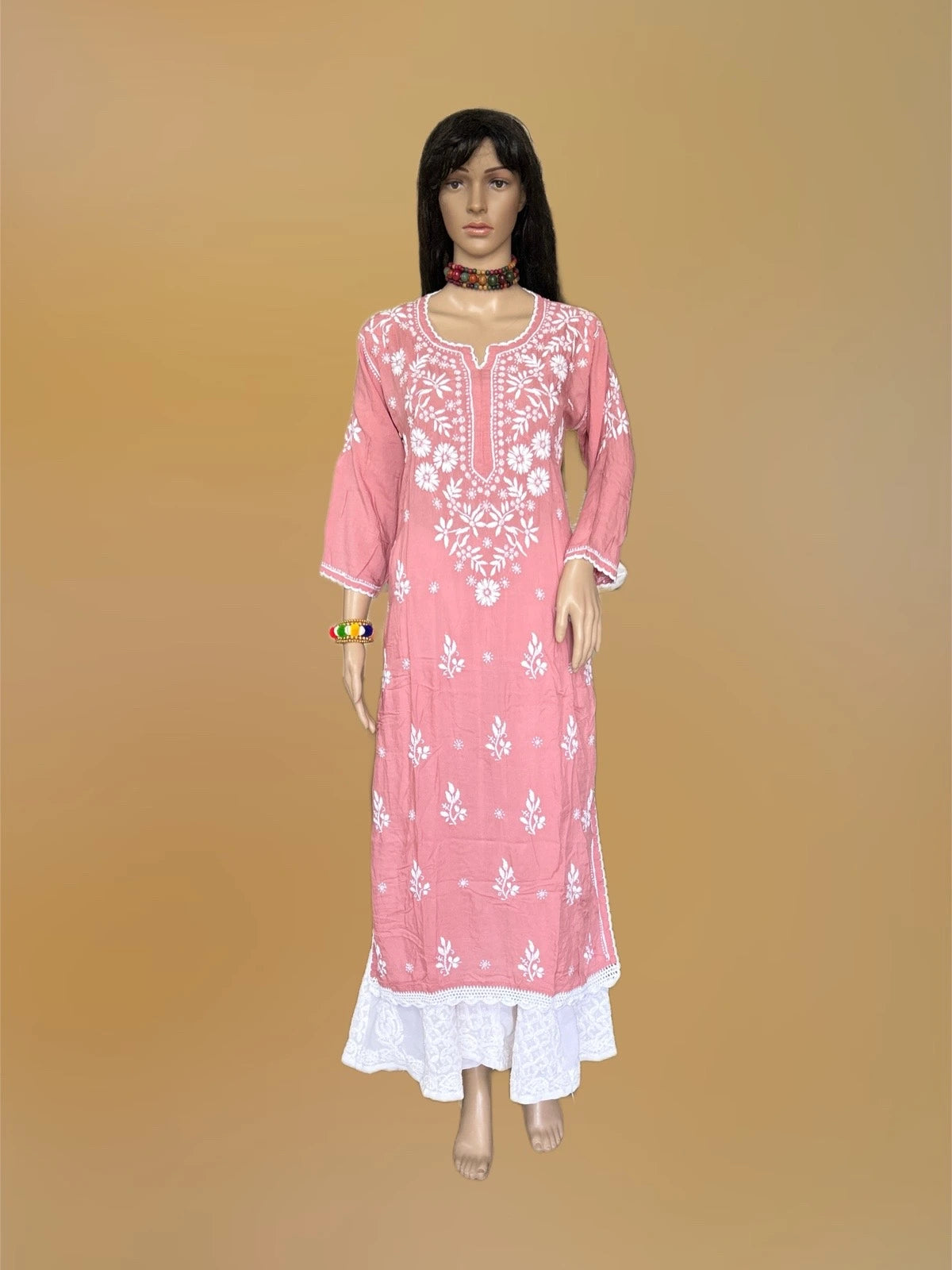 lucknowi chikankari Mannequin wearing a pink and white floral dress in a fabric store.