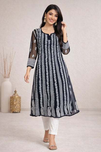 lucknowi chikankari Woman wearing a black and white patterned kurta with white pants against a neutral background