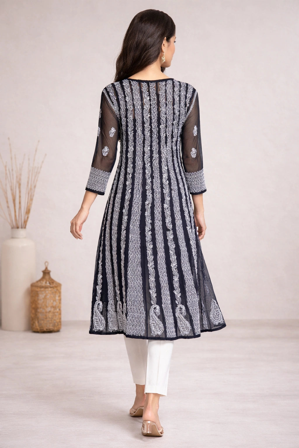 lucknowi chikankari Woman wearing a black and white patterned kurta with white pants against a neutral background