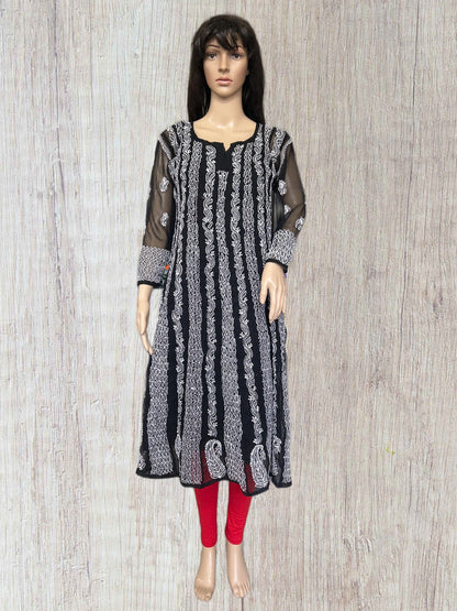 lucknowi chikankari Mannequin wearing a black and white patterned dress with red leggings on a wooden surface