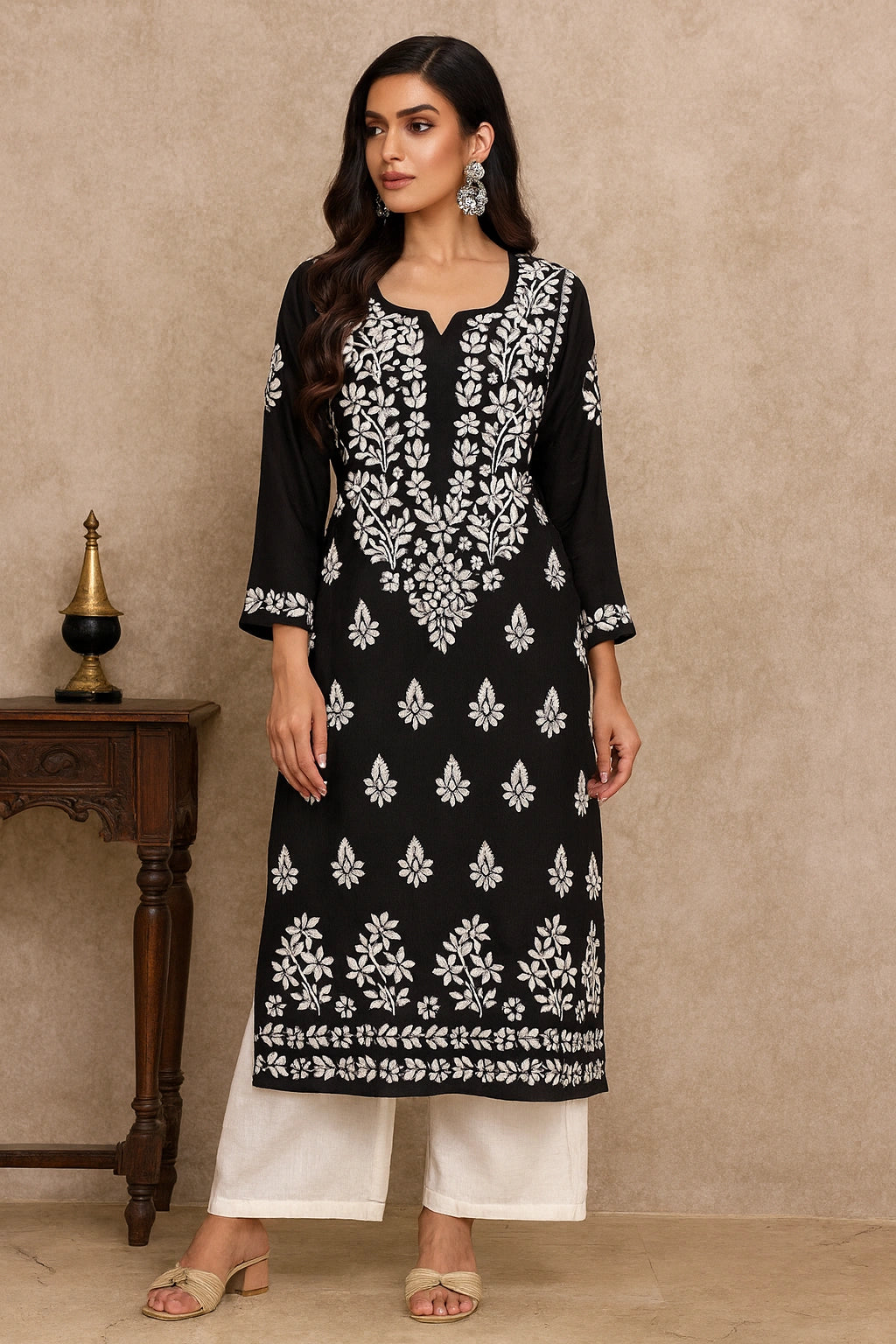 lucknowi chikankari Woman wearing a black and white patterned kurta with white pants against a beige background