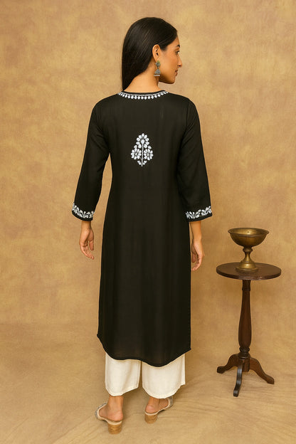 Woman wearing a black kurta with white embroidery on a beige background
