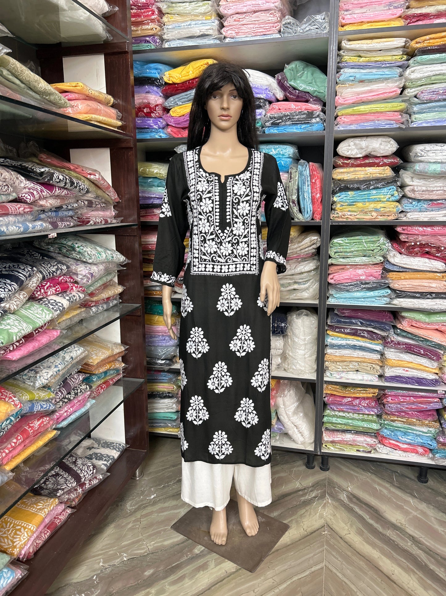 Lucknowi chikankari Mannequin wearing a black and white patterned dress in a fabric store.
