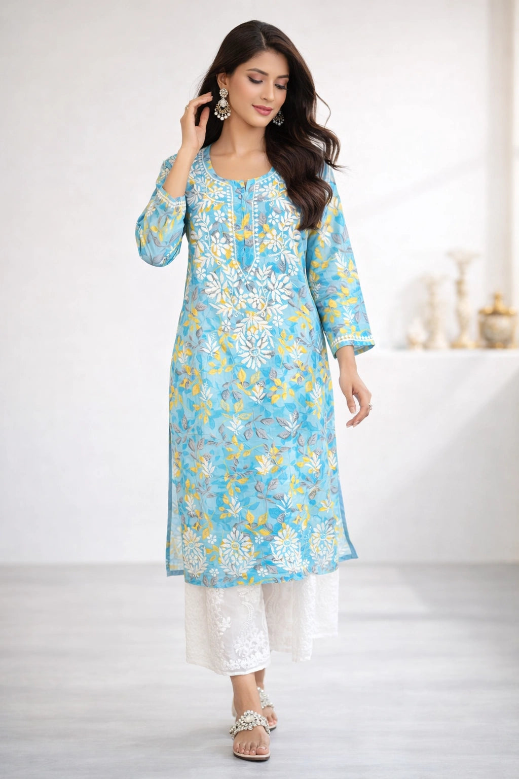 Woman wearing a lucknowi chikankari blue floral kurta with white pants on a white background