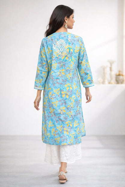 Woman wearing a lucknowi chikankari blue floral kurta with white pants on a light background