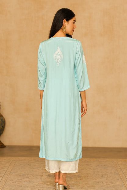 Woman wearing a light blue kurta with white embroidery on a beige background