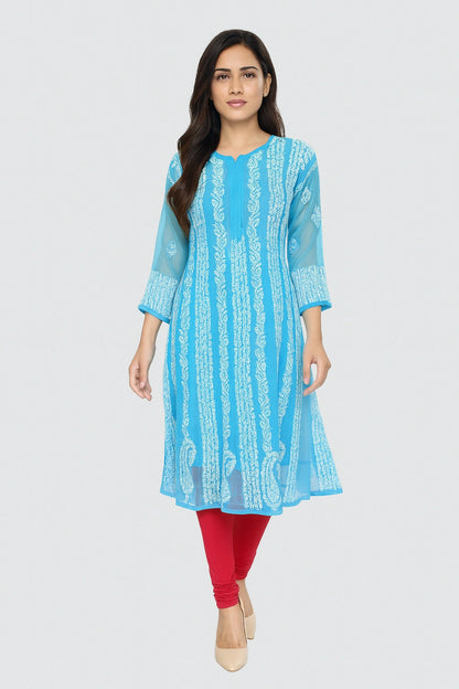 lucknowi chikankari Woman wearing a light blue kurta with white pants sitting on a chair.