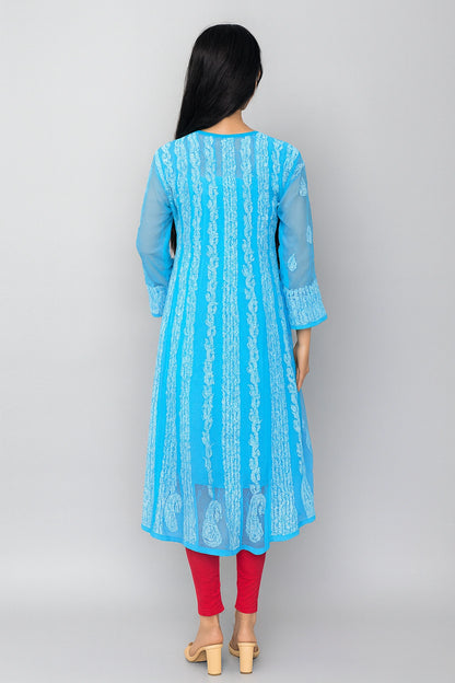 lucknowi chikankari Woman wearing a light blue kurta with white pants in a minimalistic setting.