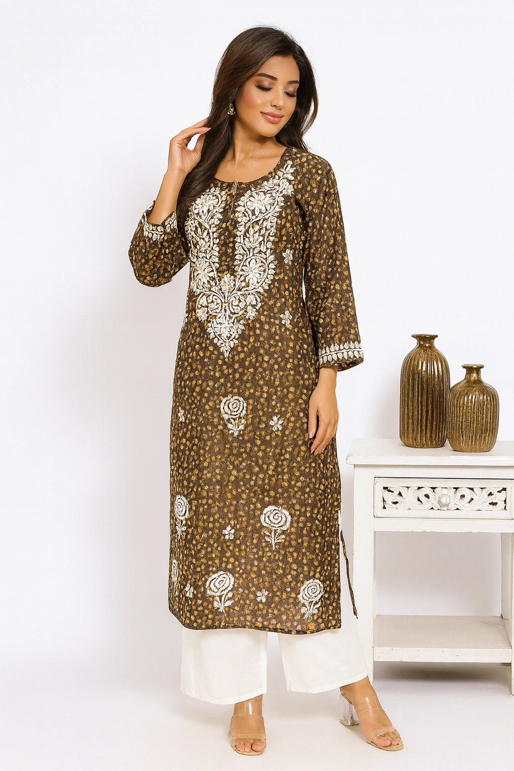 lucknowi chikankari Woman wearing a brown and white patterned kurta with white pants in a minimalistic setting.