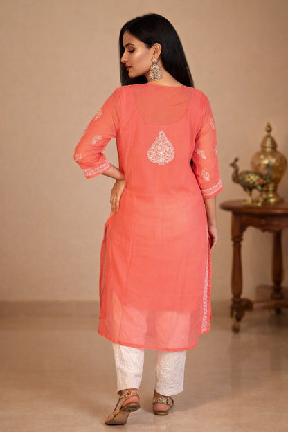 lucknowi chikankari Woman wearing a red kurta with white pants in a minimalistic setting