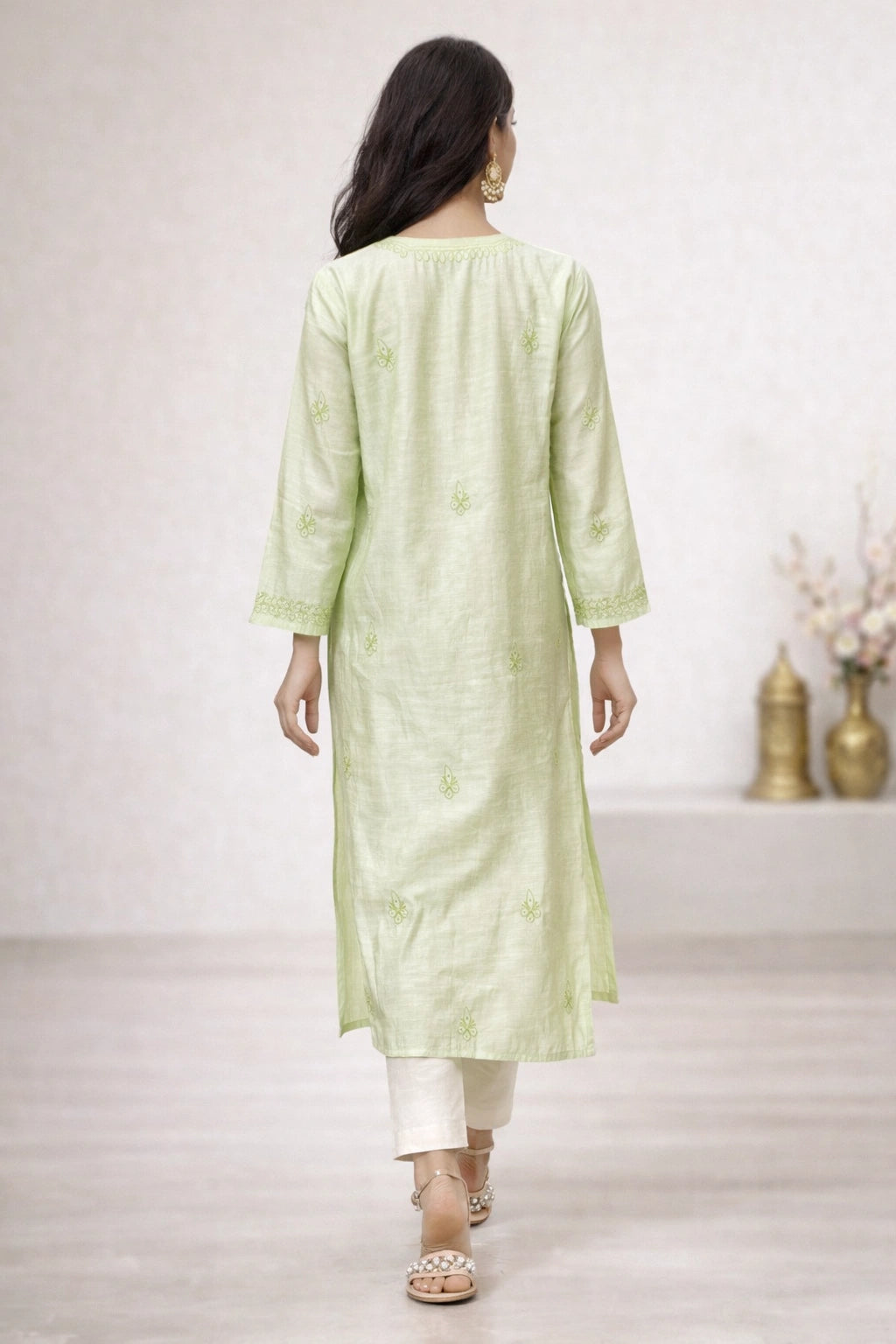 Woman wearing a light green kurta with white pants in a minimalistic setting