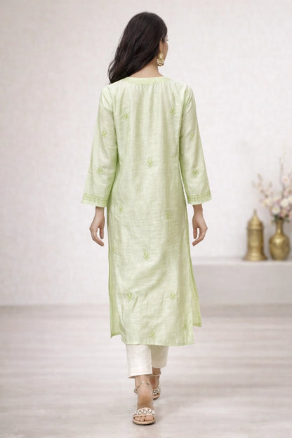 Woman wearing a light green kurta with white pants in a minimalistic setting