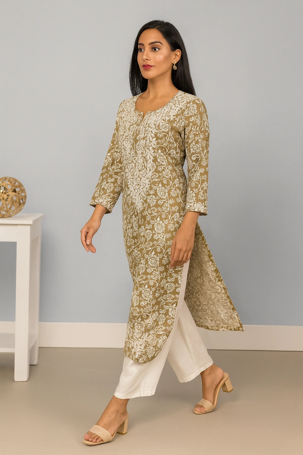 Lucknowi chikankari Woman wearing a floral kurta with white pants against a gray background