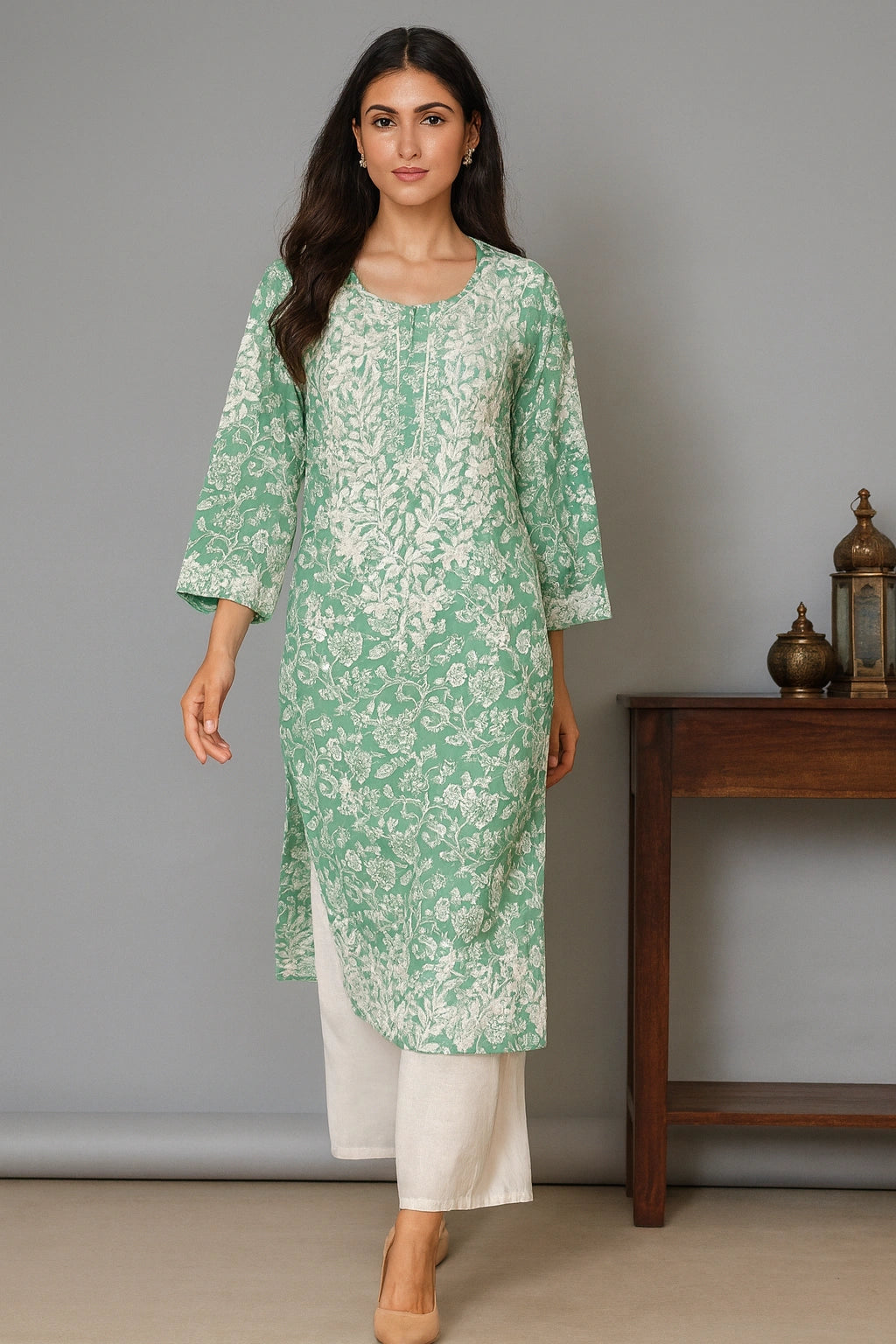 lucknowi chikankari Woman wearing a green floral kurta with white pants against a gray background