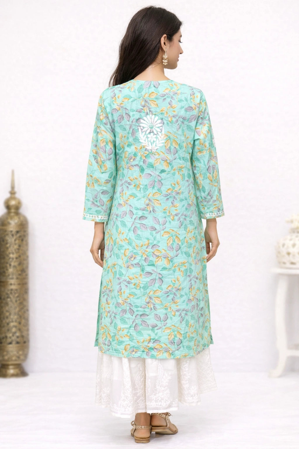 Woman wearing a lucknowi chikankari light blue floral kurta with white pants on a white background