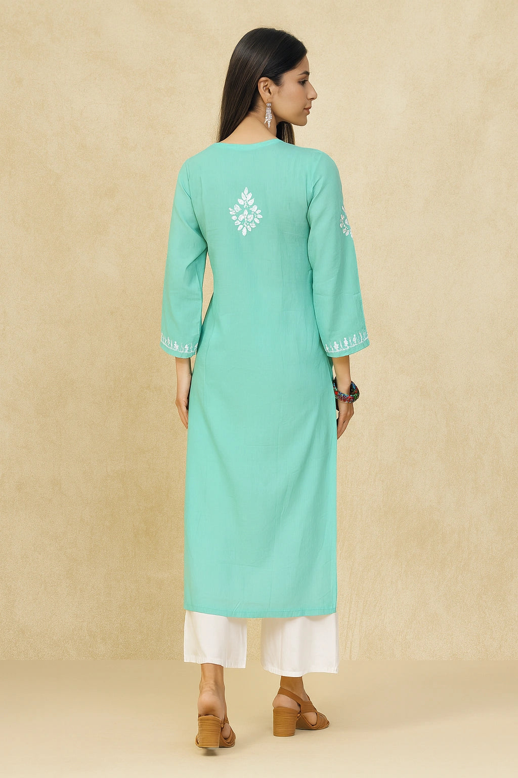 Woman wearing a light blue kurta with white embroidery on a beige background