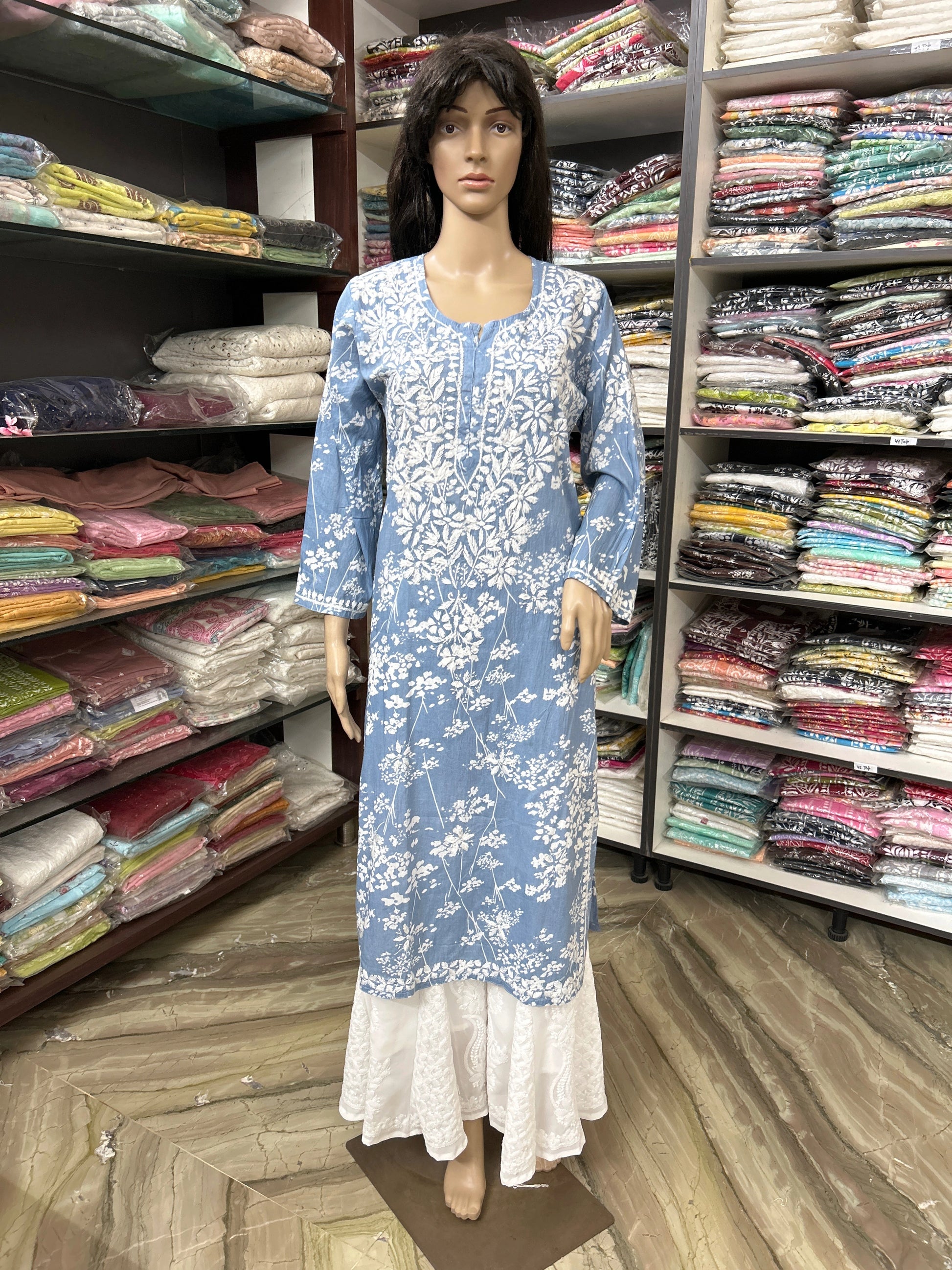 Mannequin wearing a lucknowi chikankari blue floral dress in a fabric store