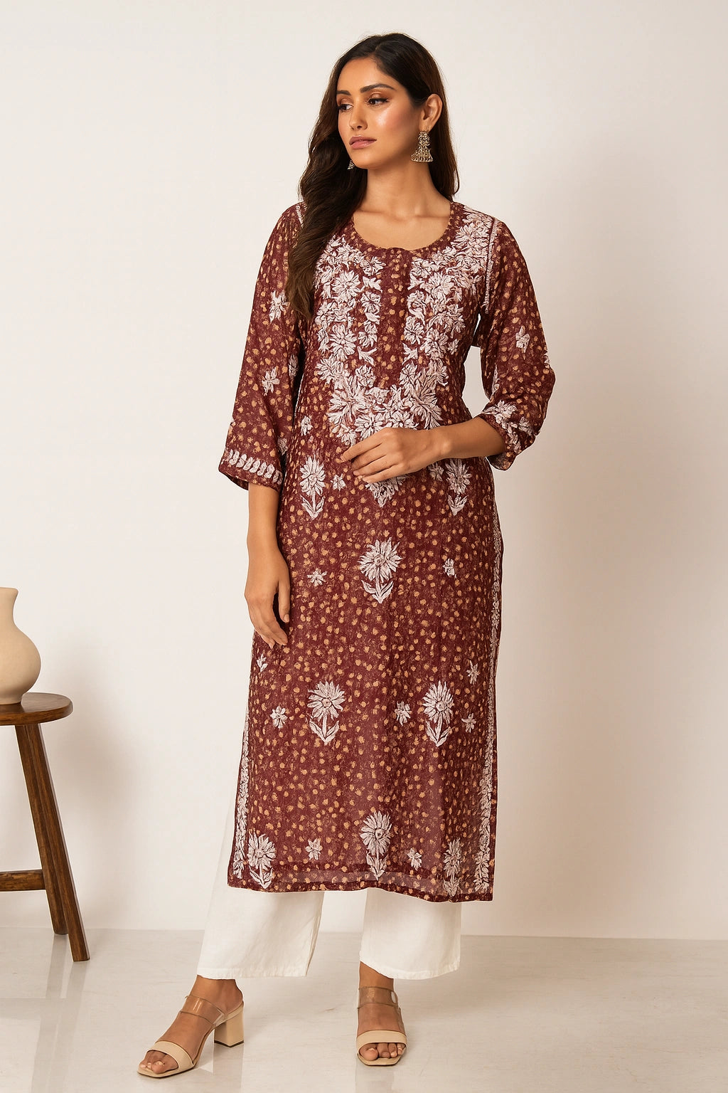 Lucknowi Chikankari Woman wearing a brown floral kurta with white pants against a plain background