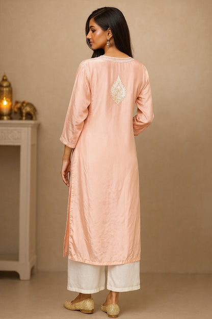 lucknowi chikankari Woman wearing a peach kurta with white pants against a beige background
