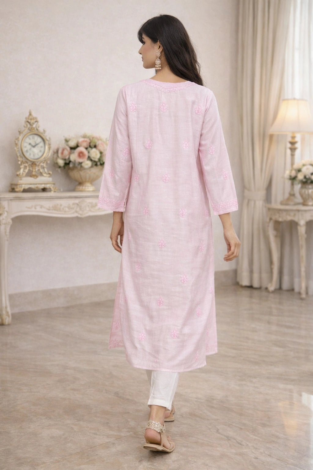 lucknowi chikankari Woman wearing a light pink kurta in a well-lit room with decorative items.