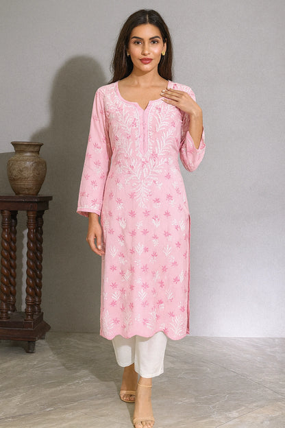 lucknowi chikankari Woman wearing a pink floral kurta with white pants against a gray background