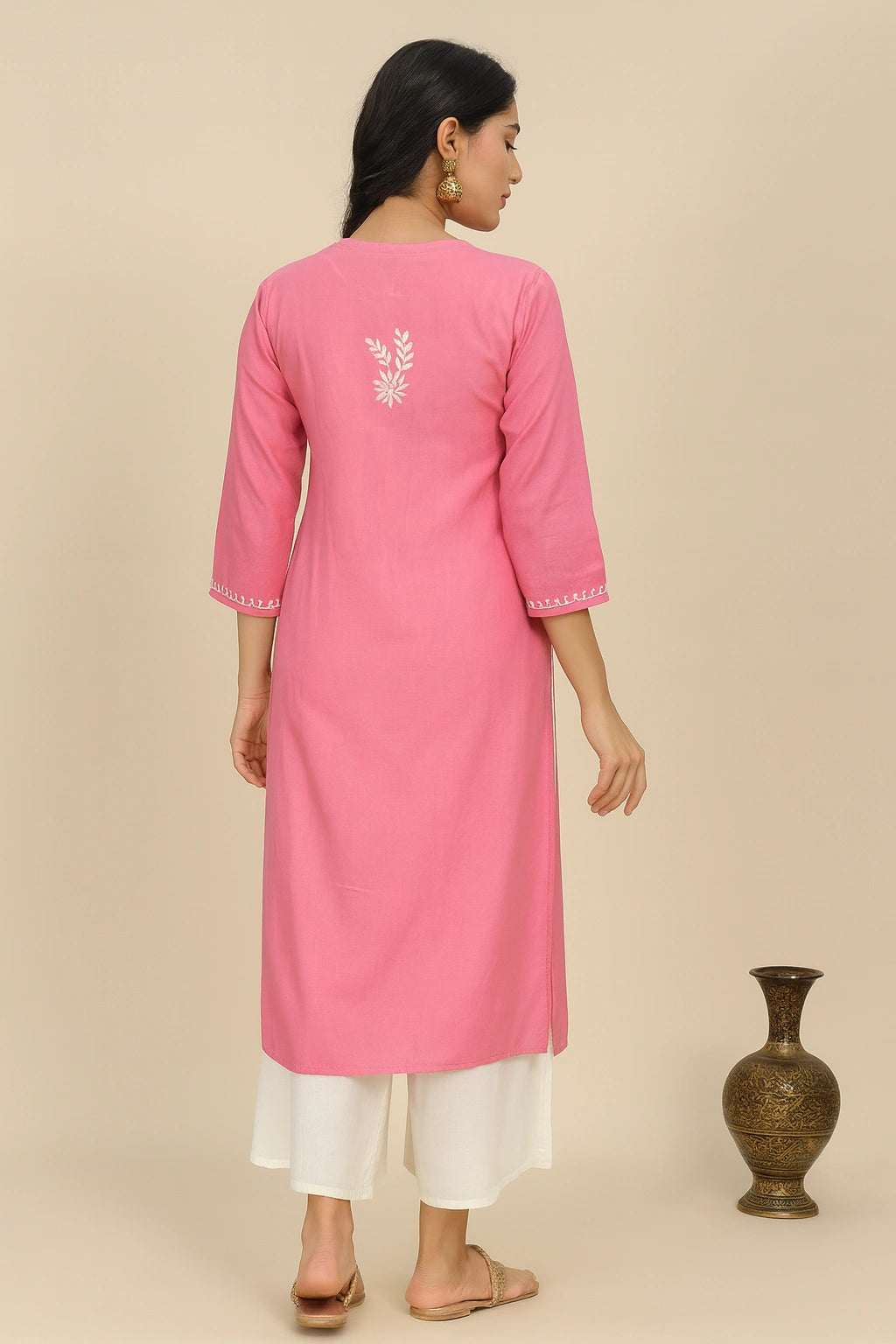 lucknowi chikankari Woman wearing a pink kurta with white pants against a beige background