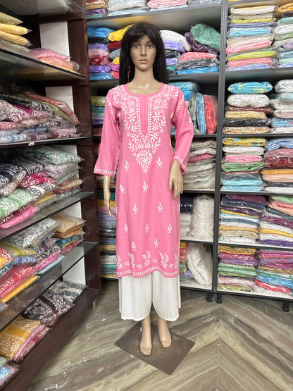 Mannequin wearing a pink embroidered outfit in a fabric store.
