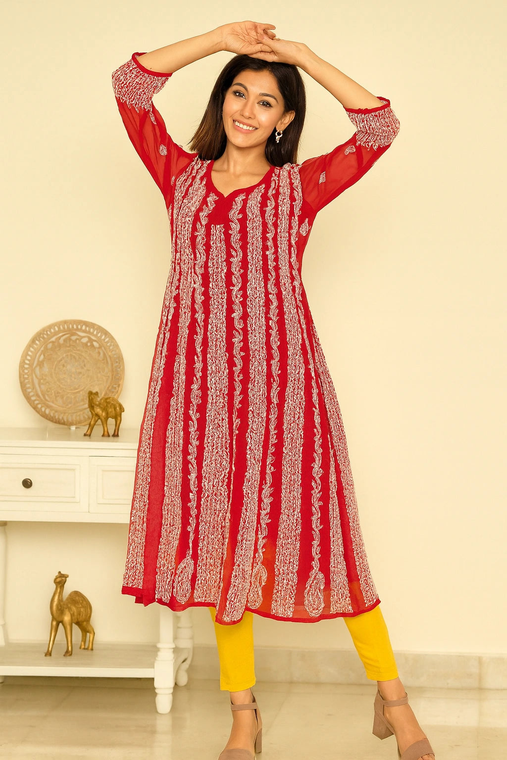 lucknowi chikankari Woman wearing a red and white patterned kurta with yellow pants in a room.