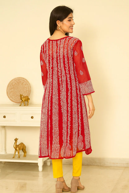 lucknowi chikankari Woman wearing a red and white patterned kurta with yellow pants in a room setting.