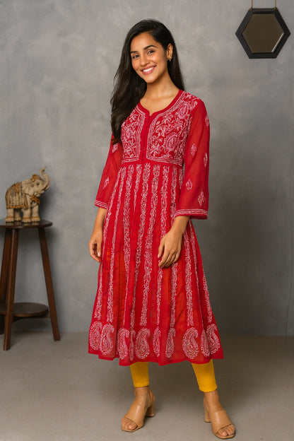 Woman wearing a red and white patterned dress standing against a gray background