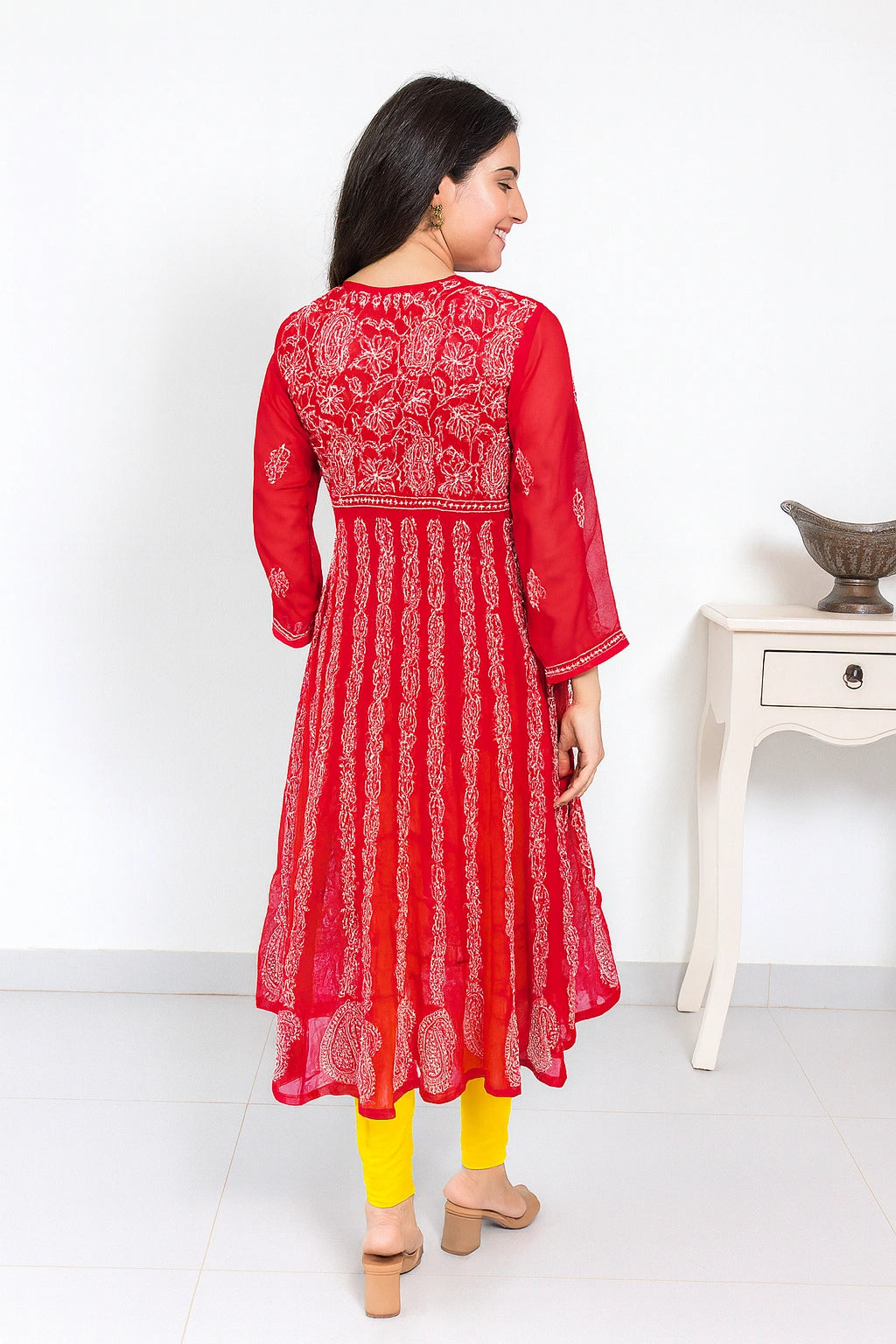 lucknowi chikankari Woman wearing a red and white patterned dress with yellow pants on a white background