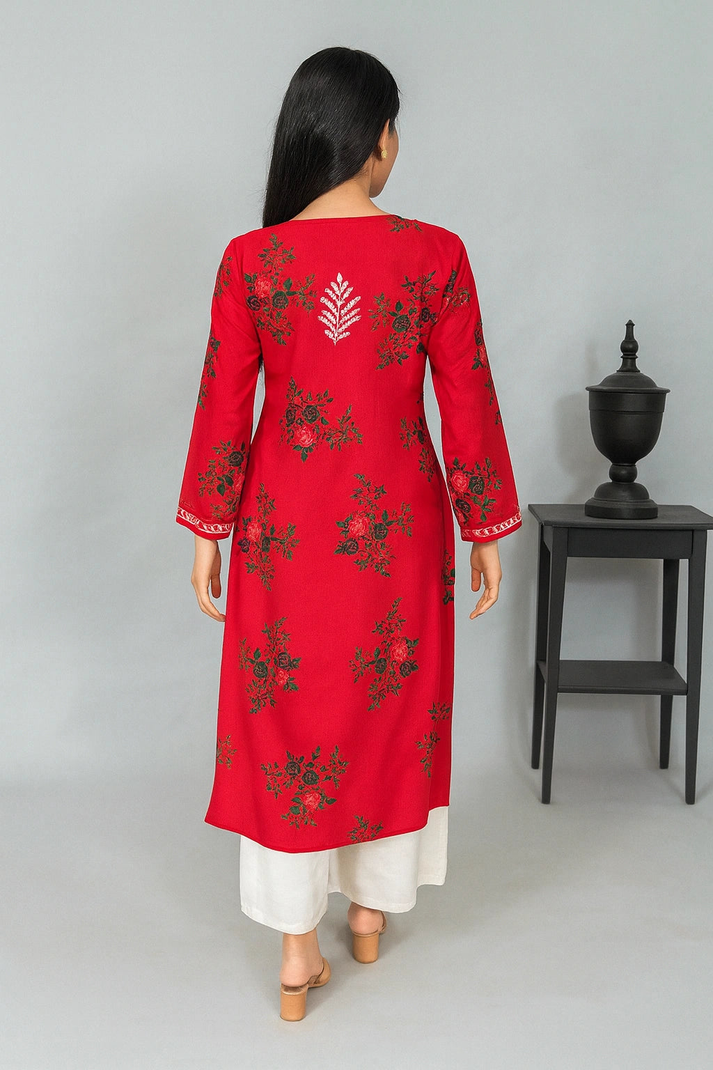 lucknowi chikankari Woman wearing a red floral kurta with white pants against a plain background