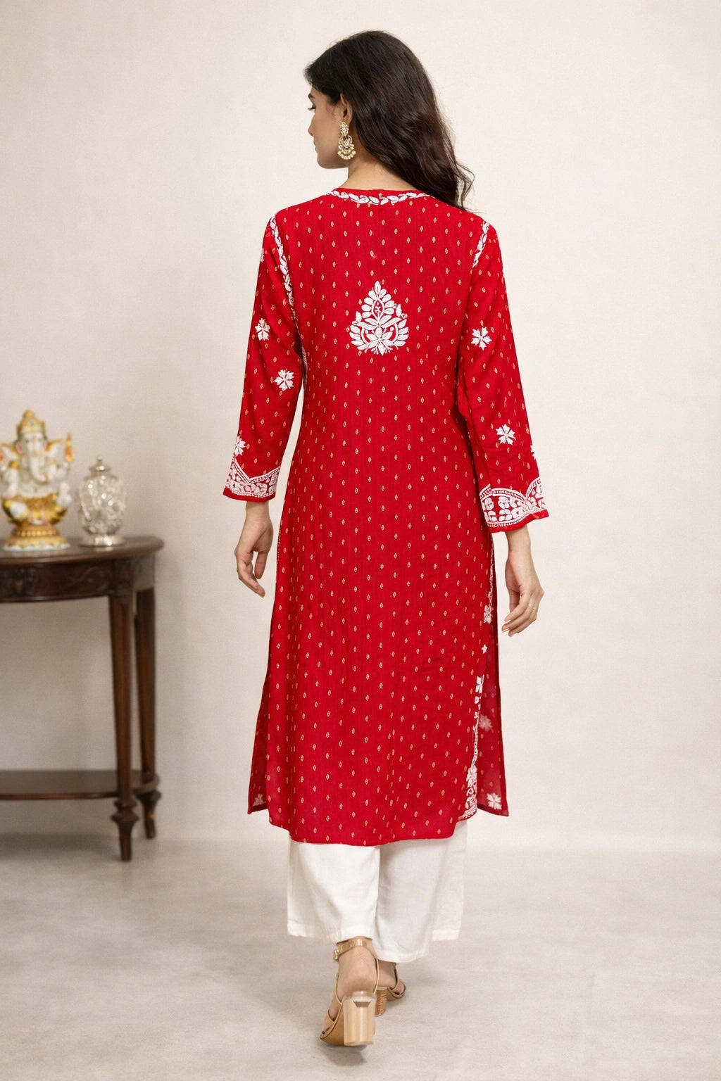 lucknowi chikankari Woman wearing a red embroidered kurta with white pants on a plain background