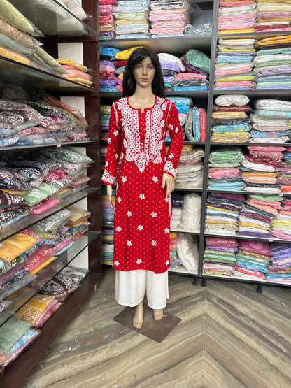 lucknowi chikankari Mannequin wearing a red and white traditional outfit in a fabric store.