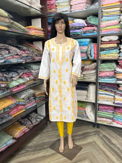 Mannequin wearing a white kurta with yellow embroidery in a fabric store.